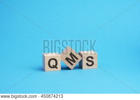 Qms Text On Wooden Blocks, Financial Business Concept, Blue Background. Qms - Short For Quality Mana