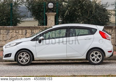 Side, Turkey -february  23, 2022: White  Ford Fiesta   Is Parked  On The Street On A Warm Day Agains
