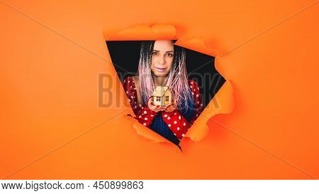 Woman With Toy House Looking Through Hole In Paper. Female With Afro Braids And Miniature Wooden Hou