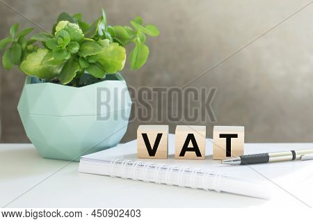 Vat 2022 On Wooden Cubes, Notebook And A Pen On A Table. Vat 2022 - Phrase From Wooden Blocks With L