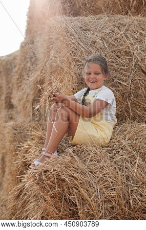 Shining Beautiful Female Child On Hayrick Smiling Looking Down And Having Some Hay In Hands Wearing 