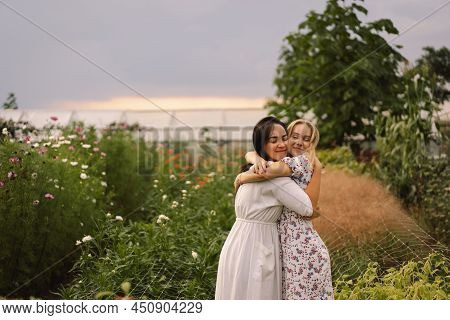 Happy Mothers Day. A Young Mother With A Teenage Daughter Spends Time In The Garden. Mom And Her Dau