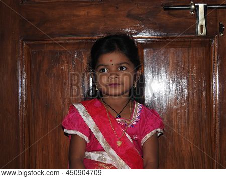 Closeup Of Beautiful Indian Girl Kid Traditionally Dressed To Distribute Makara Sankranti Or Pongal