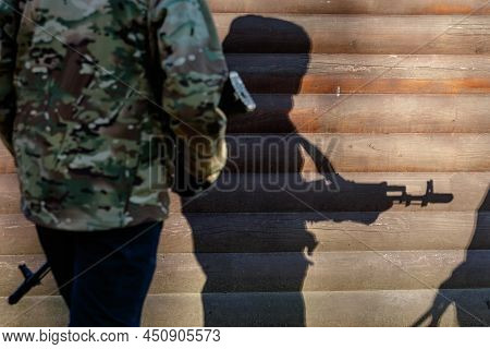 Western Ukraine - March 13, 2022: Shadow Of A Young Man With A Machine Gun. Ukrainians With Weapons 