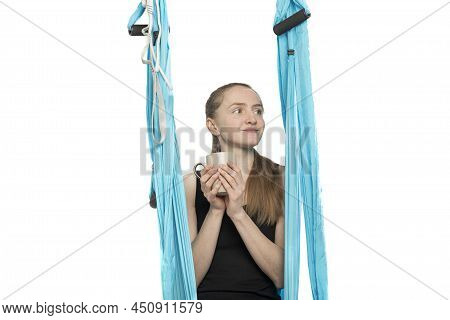 Portrait Of Cute Girl Sitting In Sports Hammock With Cup Of Tea Waiting For Start Of Yoga Classes. W