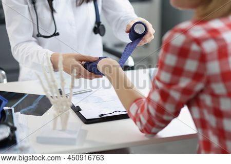 Close-up Of Physiotherapist Applying Bandage On Patient Hand, Post Traumatic Rehabilitation, Sport P