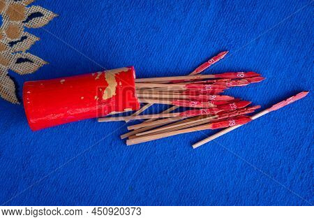 Bamboo Cylinder With Fortune Sticks Or Esiimsi Falling On The Floor Before Someone Shaking It. In Ch