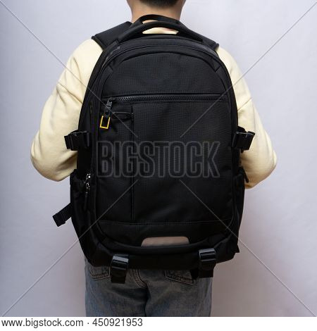 Asian Child Standing With A Black Backpack