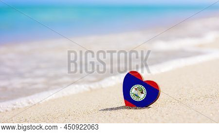 Flag Of Belize In The Shape Of A Heart On A Sandy Beach. The Concept Of The Best Holiday In Belize