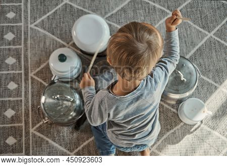 Child Drummer Having Fun Drum Playing On Kitchen Pans At Home