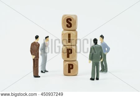 Business And Finance Concept. On A White Background, Figures Of Businessmen Look At Wooden Cubes Wit
