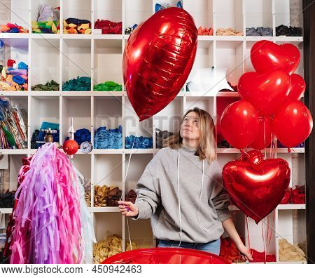 Woman With A Large Red Ball Of Foil In The Shape Of Heart.