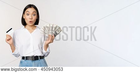 Finance And Money Concept. Happy Young Asian Woman Dancing With Cash And Credit Card, Smiling Please