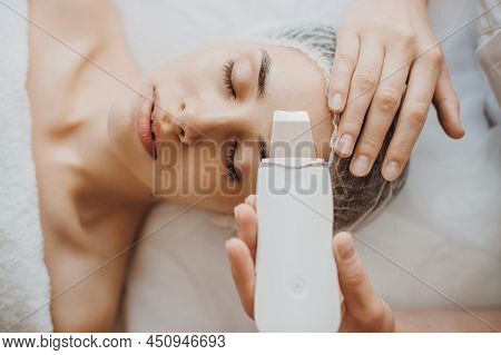 Top View Of A Caucasian Woman Getting Skin Analized By Cosmetologists Hands, Using Skin Analyzer.edi