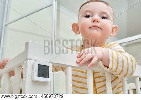 Measuring The Temperature And Humidity Of The Infant Baby In The Nursery. The Device Is A Thermomete