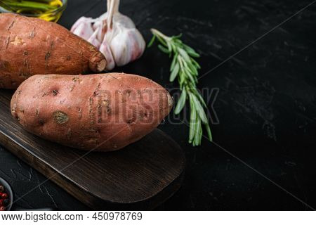 Sweet Potato Or Batat With Herbs And Spices On Black Background With Space For Text.