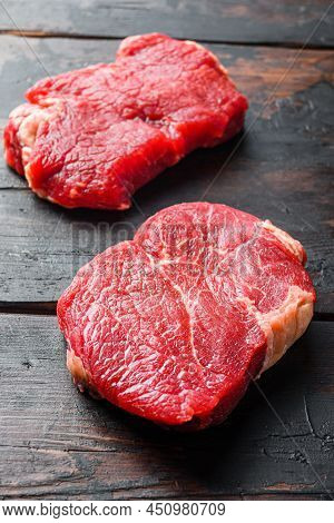 Raw Rumpsteaks Over Dark Old Wooden Background, Side View