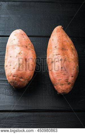 Sweet Potato Or Batat, On Black Wooden Background.