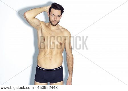 Athletic And Strong Handsome Caucasian Man Wearing Contrasty Underware Outfit And Posing With Lifted