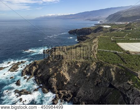 Aerial View On Charco Del Viento Natural Pool In Black Lava Rocks And Banana Tree Plantation On Tene