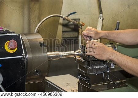 The Turning Machine Operator Working With Lathe Machine. The Metalworking Process By Turning Machine