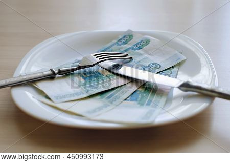 Russian Rubles On A White Plate, Close-up, Selective Focus. Keep Money On The Fork. Minimum Subsiste