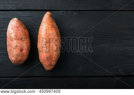 Sweet Potato Or Batat, On Black Wooden Background, Top View With Space For Text.