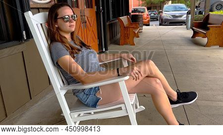 Woman Sits In A Rocking Chair At Cracker Barrel - Homestead, Florida - February 20, 2022