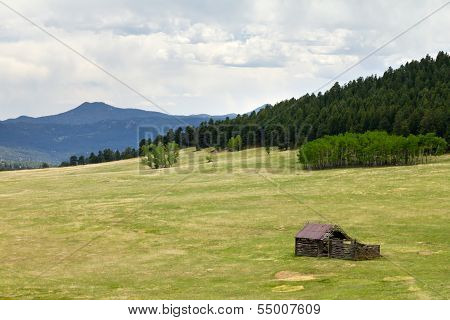 Old Wood Cabin In A Mountain Field