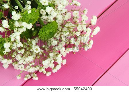 Beautiful flowers on wooden background