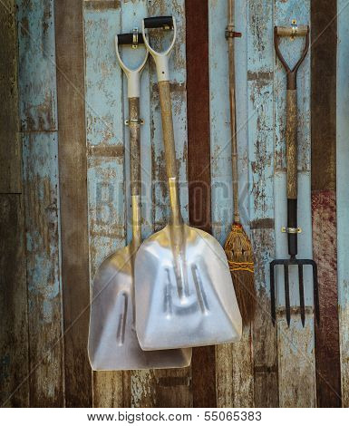 farm tool pitchfork and two shovels against old wooden wall use as rural farm scene