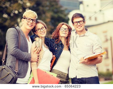 summer holidays, education, campus and teenage concept - group of students or teenagers with files, folders and eyeglasses hanging out
