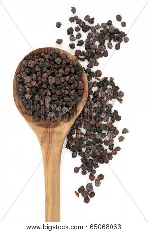 Schisandra berry fruit used in chinese herbal medicine in a wooden spoon over white background.  Wu wei zi. 
