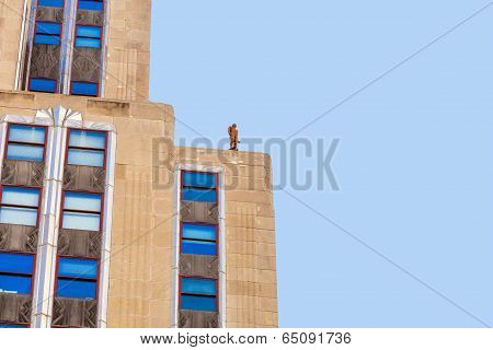 Facade Of Skyscraper With Statue Of Man