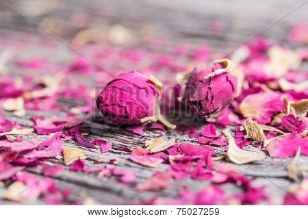 Dry rose buds on rustic wooden table