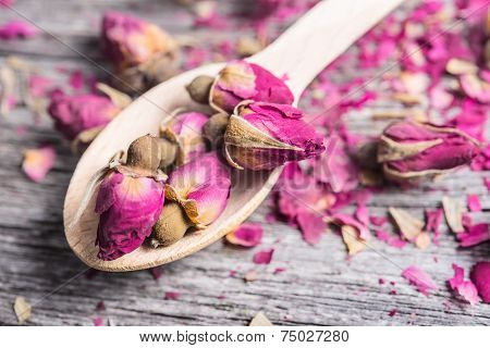 Dry rose buds on rustic wooden table