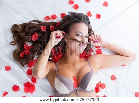 Portrait of funny lingerie model posing in bed
