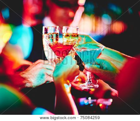 Hands of friends with cocktails making toast at party