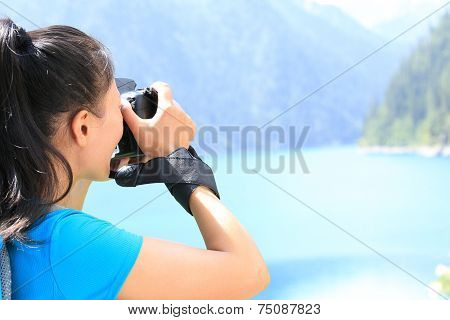 woman tourist/photographe r taking photo with digital camera in jiuzhaigou national park,china