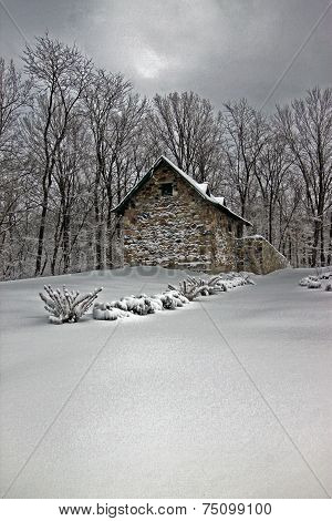 old smokehouse in the snow