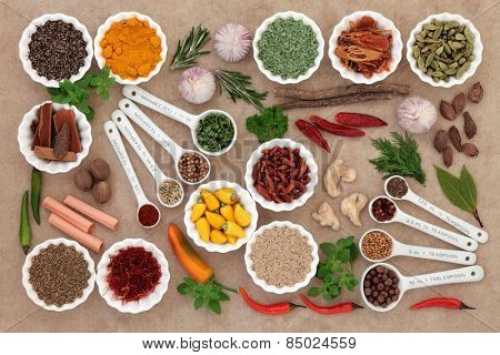 Herb and spice collection in measuring spoons and crinkle bowls.