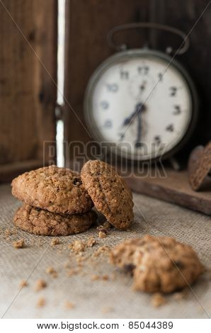 Chocolate chip cookies on jute fabric with vintage allarm clock