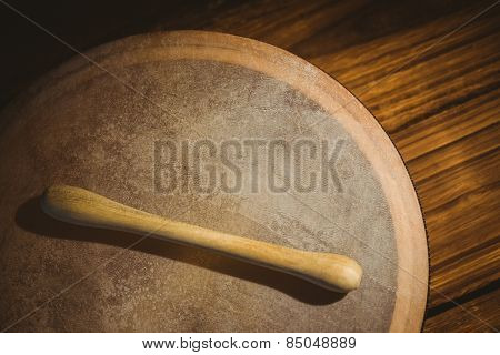 Traditional Irish bodhran and stick on wooden table