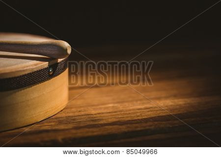 Traditional Irish bodhran and stick on wooden table