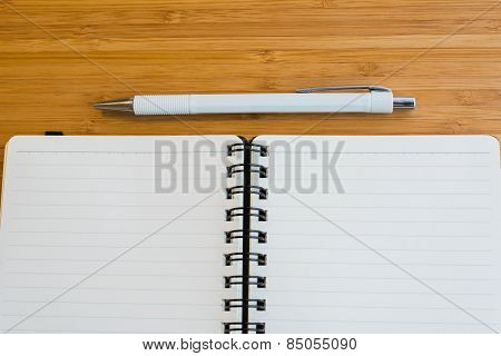 Note book and pencil on the wooden table.