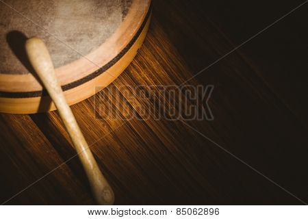 Traditional Irish bodhran and stick on wooden table