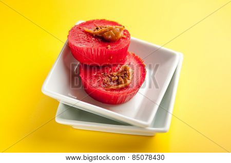 Kutsinta - a Filipino sweet rice cakes in white plates on bright yellow background.