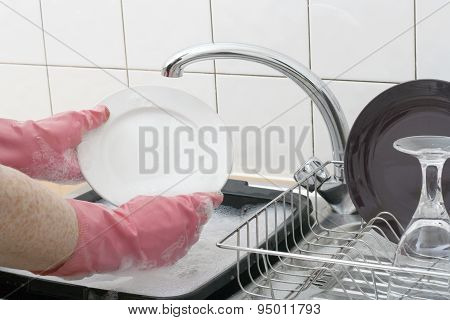Washing the dishes in kitchen domestic scene