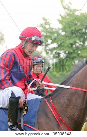 Two Jockeys Sitting On Their Race Horses