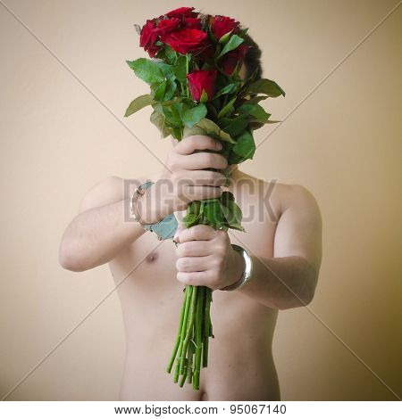 Young Man Holding Red Rose In Hand With Handcuffs